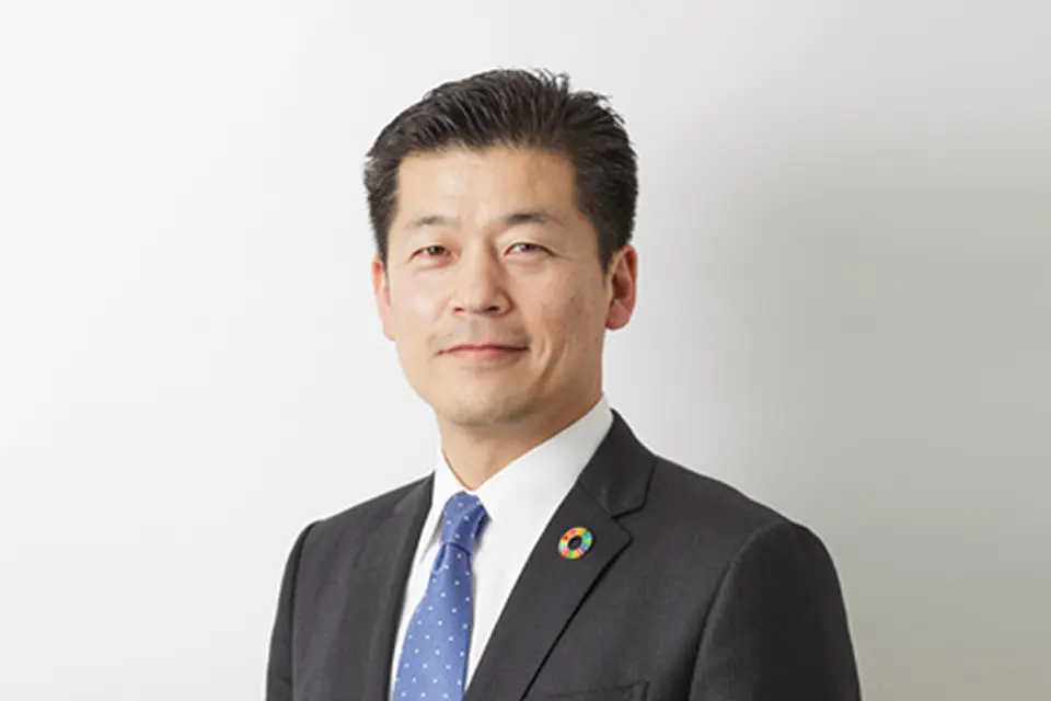 スーツ姿で正面を向いて微笑んでいる社長
