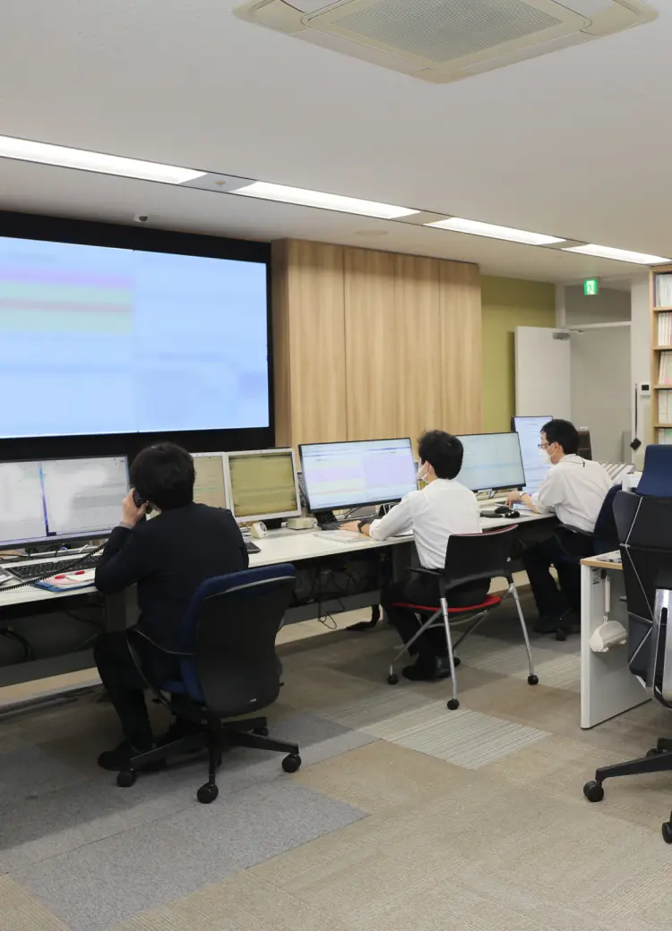 複数のモニターに向かって作業を行うスタッフたちの管制室・オフィスの様子